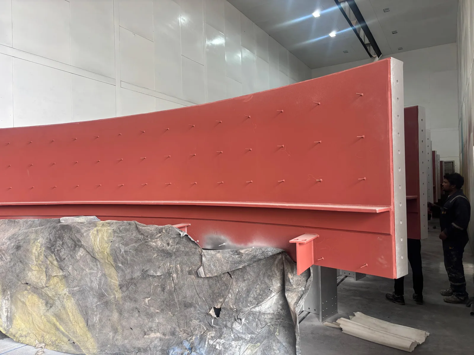 A red-primed chamber panel with studs welded to its outer face